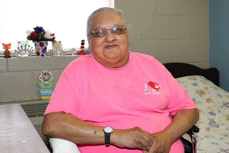 A senior woman smiling while sitting in a chair