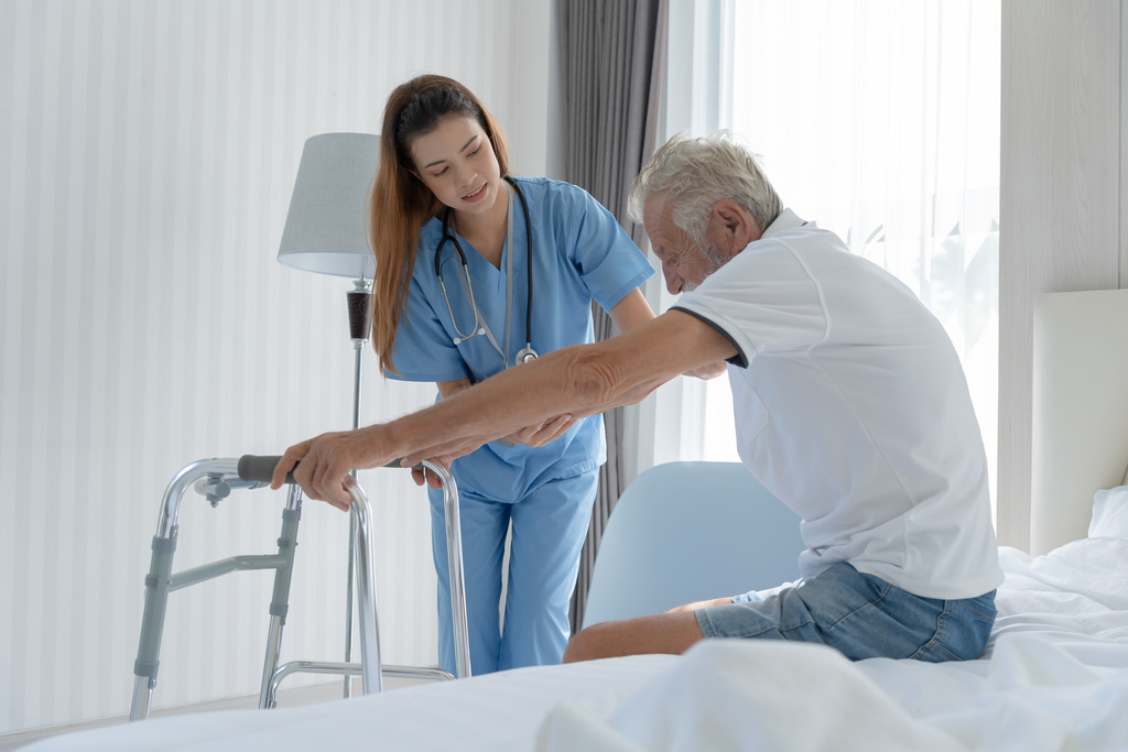 A Nurse Assisting an Elderly Man Stand Benefits of a Skilled Nursing Facility