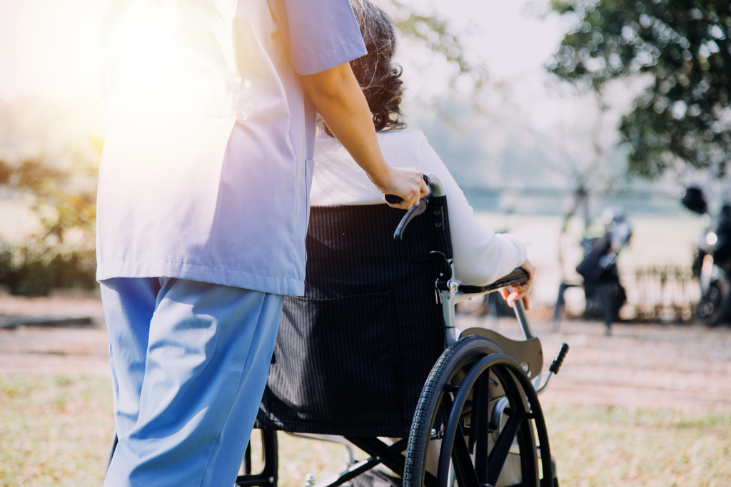 Skilled Nursing Facility Employee Pushing A Wheelchair