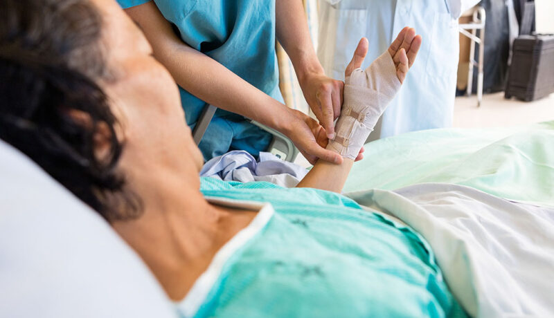 Many seniors face chronic wounds that are difficult to manage. Discover 5 ways a skilled nursing facility addresses non-healing wounds in elderly adults. Closeup Of A Nurse Adjusting The Bandage On A Senior Woman's Hand Non-Healing Wounds In Elderly