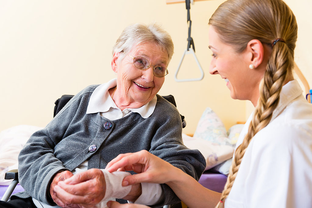 A Wound Care Specialist Bandaging a Wound on a Senior Woman’s Wrist