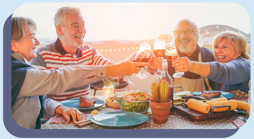 A group of senior adults smiling around a table while having a toast
